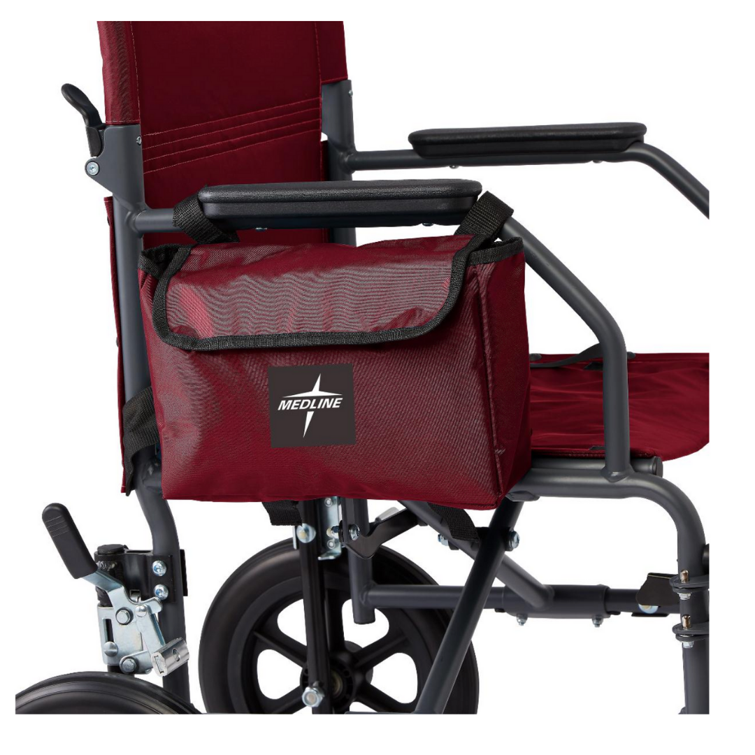 A close-up of a maroon Medline transport wheelchair shows the Medline Side Bag for Transport Chairs & Wheelchairs attached to the armrest, conveniently holding essentials and visible alongside part of the wheels and frame.